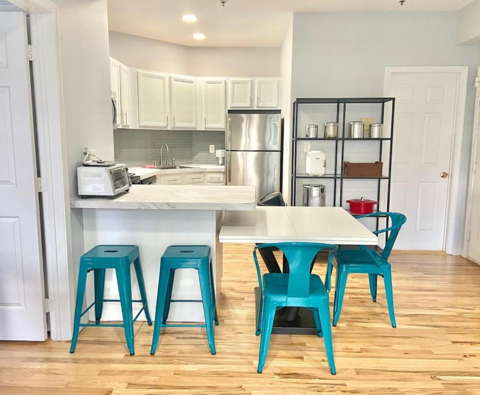 a kitchen with a table and four blue stools at 204-Bright 2Bed 2Ba w Stainless Steel Appliances in Hoboken