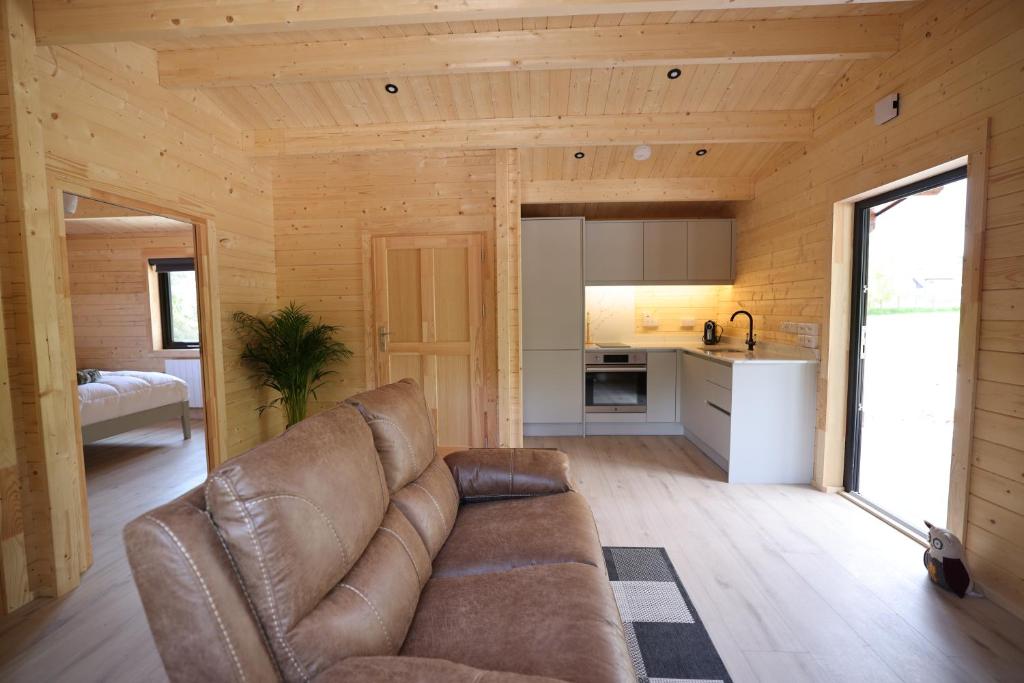 a living room with a couch and a kitchen at KillarneyCabins ie, Stunning Timber Lodges in Killarney
