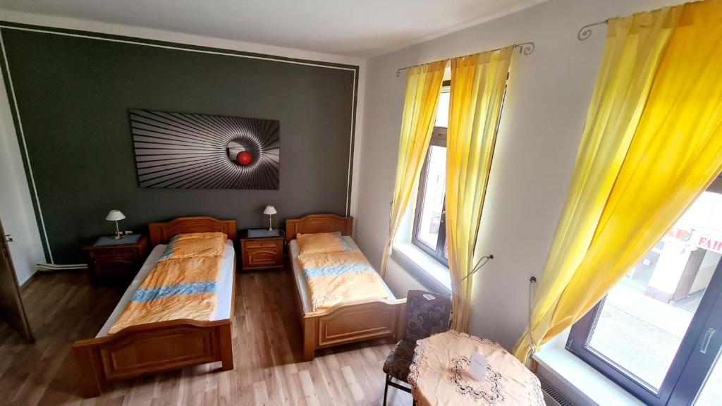 バート・フライエンヴァルデにあるHotel-Garni "Zum Löwen"のベッド3台と窓2つが備わる客室です。