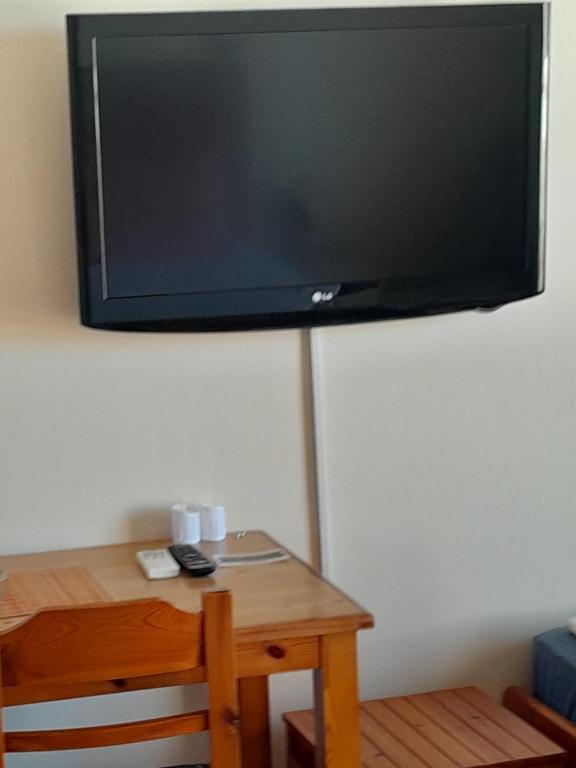 una TV a schermo piatto appesa a un muro di Santi house a Souvala