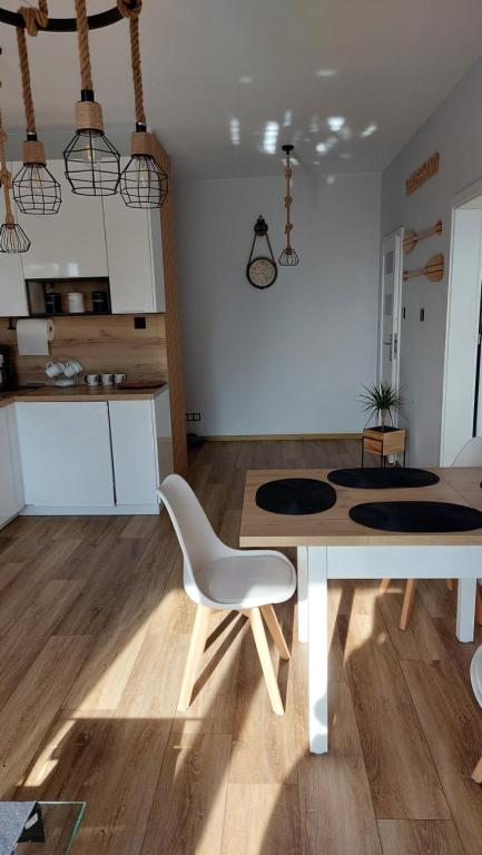 a dining room with a table and a white chair at Apartament Morski nr 4 Baltic Nova in Władysławowo