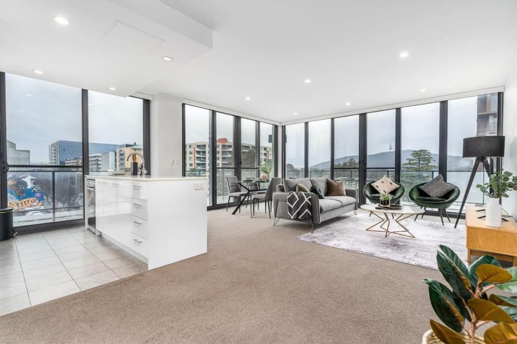 una sala de estar abierta con muchas ventanas en Roomy 2BR 2BA City-Centre Apt - Hosted by CanStay, en Canberra