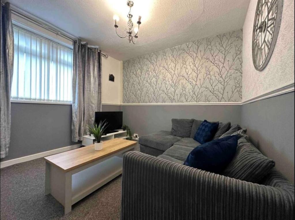 uma sala de estar com um sofá e uma mesa em Charming 2-BR Property - Sleeps 5 em Warrington