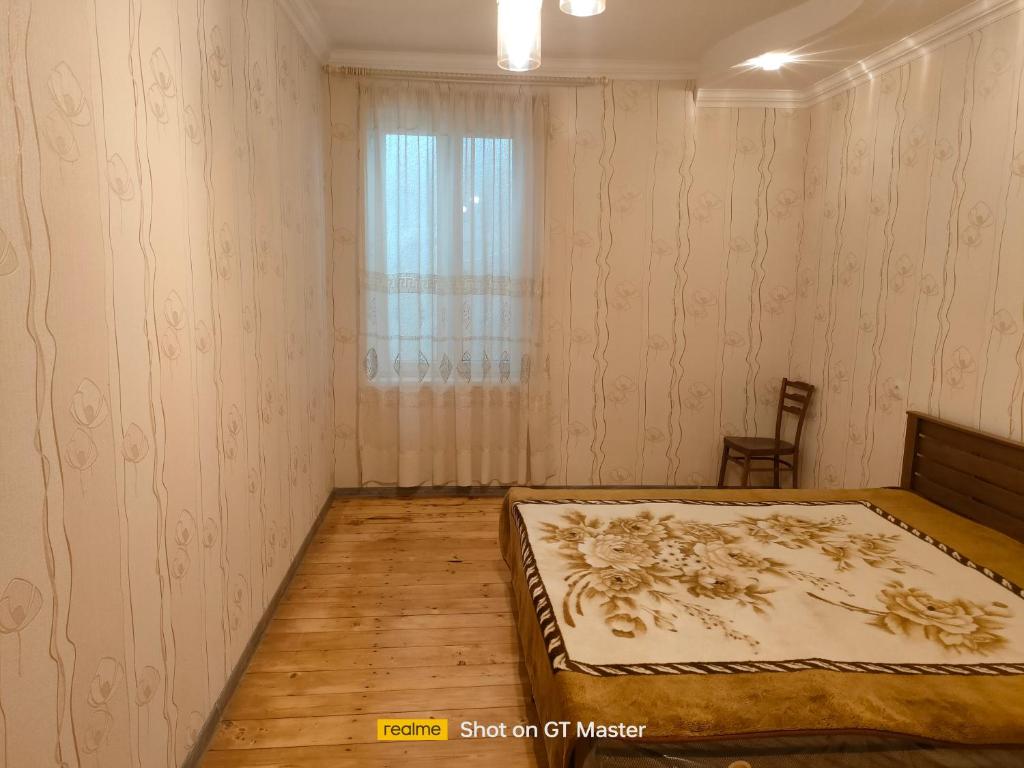 1 dormitorio con cama y ventana en Дом для одыха, en Tiflis