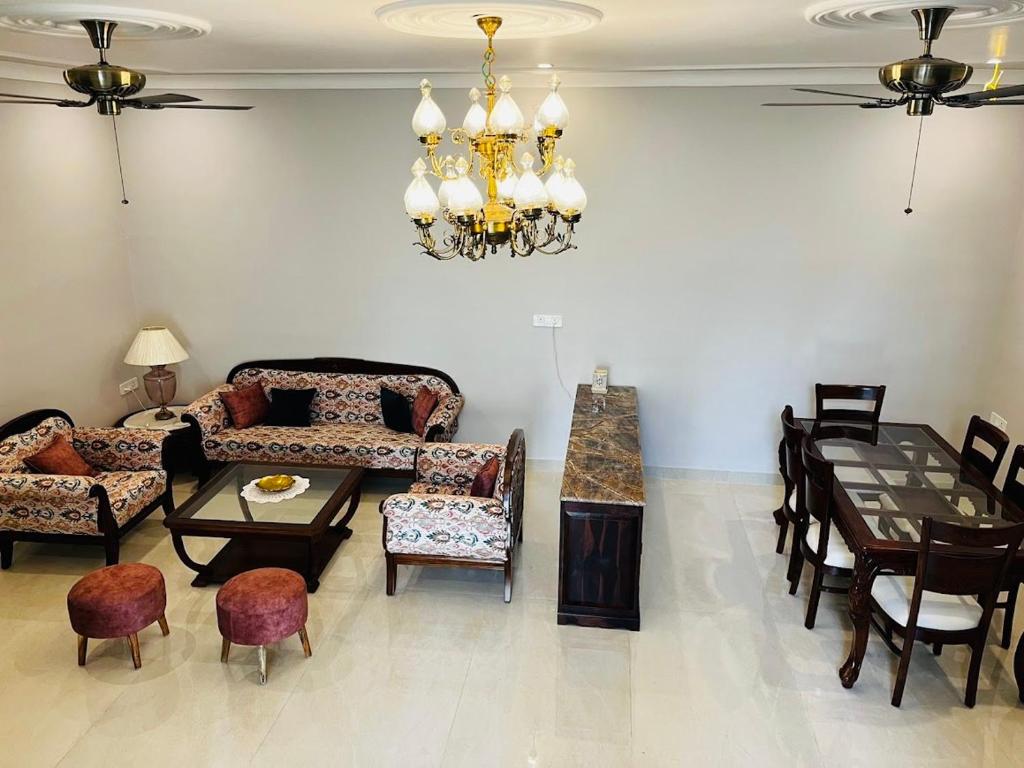 a living room filled with furniture and a chandelier at Chitawa Haveli - A Luxury Heritage Hotel in Jaipur