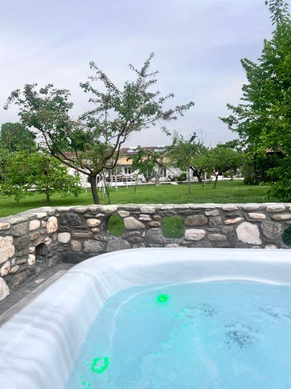 een groot zwembad met een stenen muur bij Natura villa with jacuzzi in Limenas