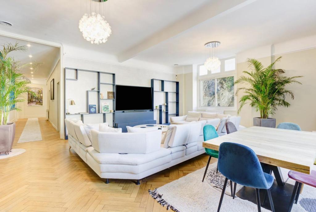 Il comprend un salon doté d'un mobilier blanc et d'une télévision à écran plat. dans l'établissement Le Palais Beausite - Palais à Cannes, à Cannes
