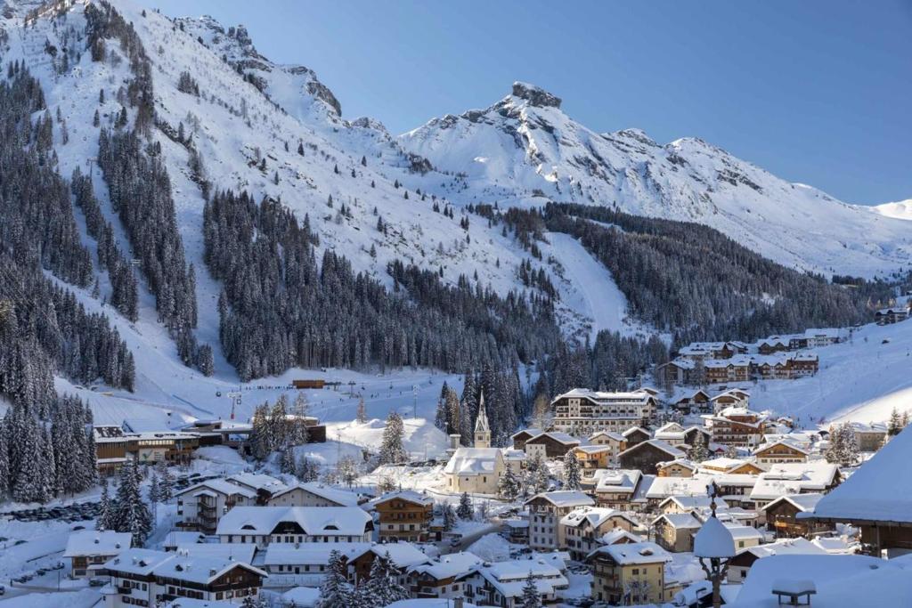 a town covered in snow in front of a mountain at Appartamenti Detomaso in Masarei