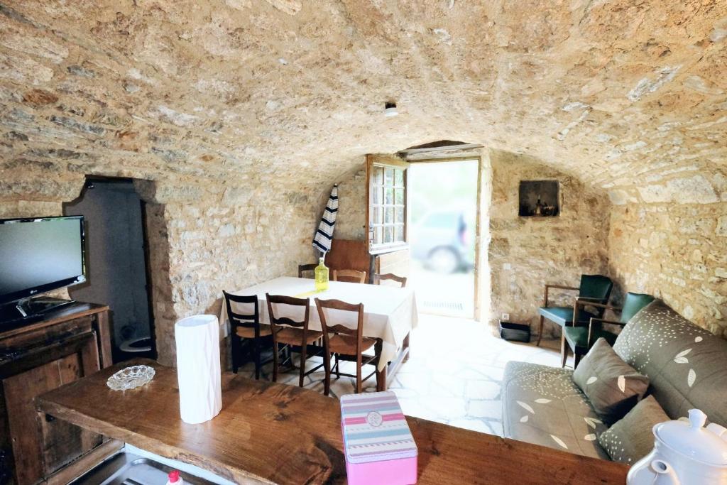 a living room with a table in a stone wall at Maison d&#39;une chambre avec jardin clos a Tour de Faure in Tour-de-Faure