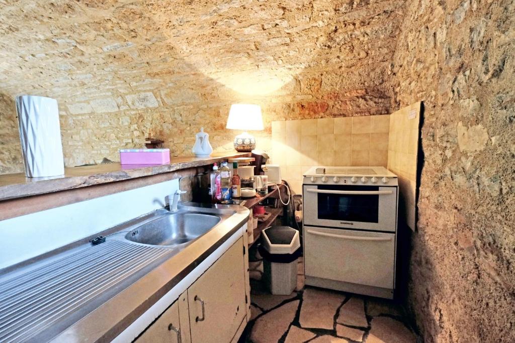 a kitchen with a sink and a stone wall at Maison d&#39;une chambre avec jardin clos a Tour de Faure in Tour-de-Faure