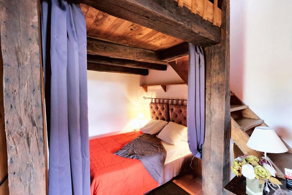 a bedroom with a wooden bunk bed with blue curtains at Maison d&#39;une chambre avec jardin clos a Tour de Faure in Tour-de-Faure