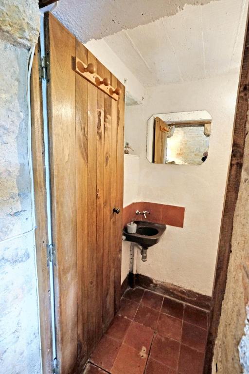 a bathroom with a sink and a wooden door at Maison d&#39;une chambre avec jardin clos a Tour de Faure in Tour-de-Faure