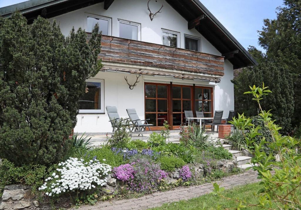une maison avec des chaises et des fleurs devant elle dans l'établissement 90m² Top Holiday Home Upper Bavaria + Munich South, à Schäftlarn