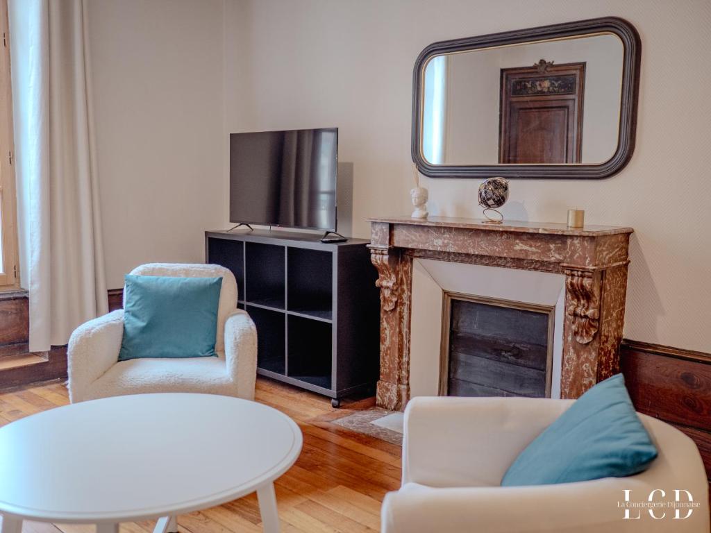 un salon avec une cheminée et un miroir dans l'établissement Le Berbisey Dijon Centre, à Dijon