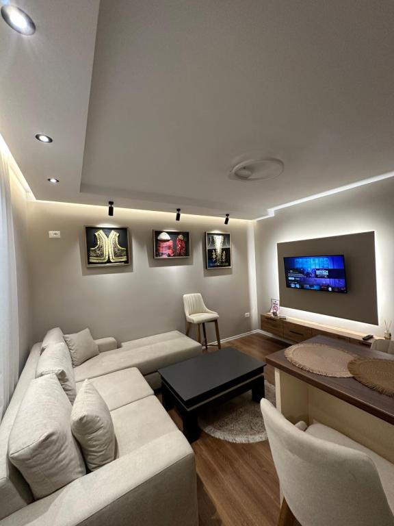 a living room with a couch and a flat screen tv at Luxury Center Apartments in Tirana