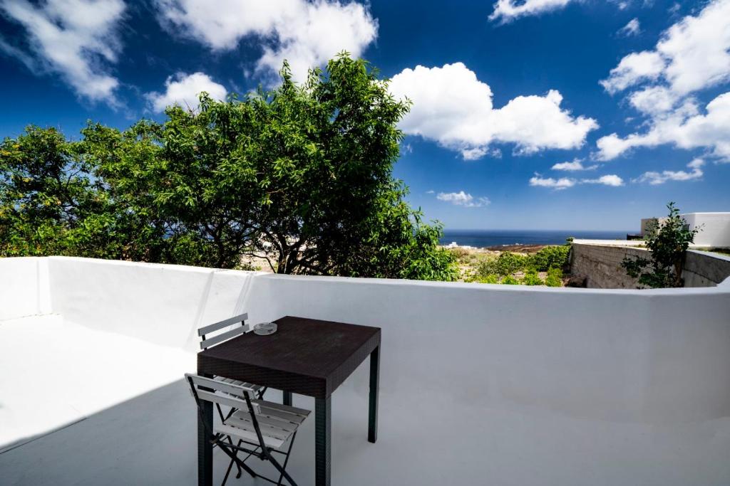 stół na białej ścianie z widokiem na ocean w obiekcie Angel Santorini Residences w mieście Vourvoúlos
