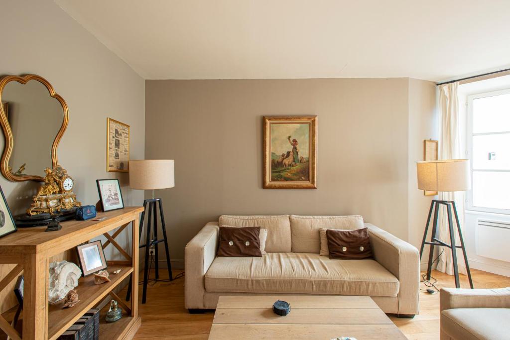 sala de estar con sofá y espejo en Maison De Charme En Bourgogne en Saint-Gengoux-le-National