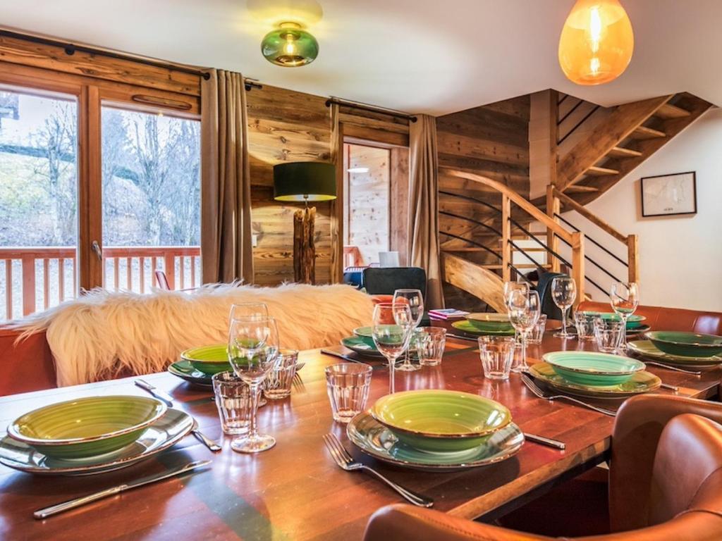 une salle à manger avec une table en bois et des verres à vin dans l'établissement Spacieux Appartement 4 Chambres avec Wi-Fi et Garage aux Gets - FR-1-671-252, aux Gets