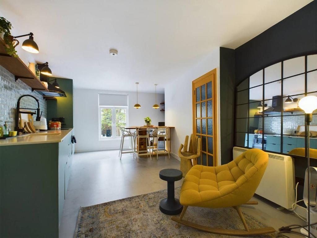 a living room with a yellow chair and a kitchen at Pass the Keys Stylish and Modern 2Bed 2Bath Hackney Apartment in London