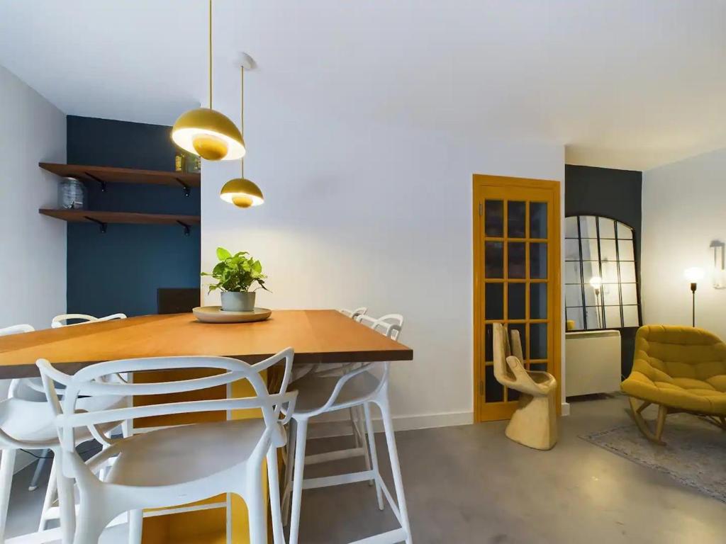 a dining room with a wooden table and white chairs at Pass the Keys Stylish and Modern 2Bed 2Bath Hackney Apartment in London