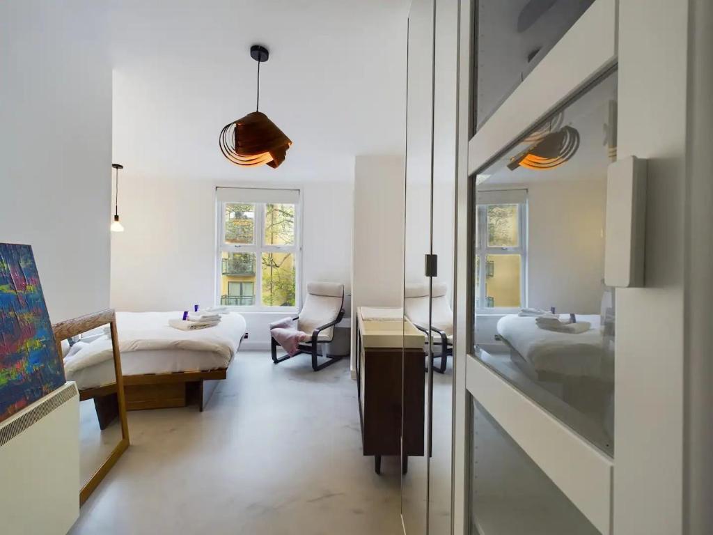a bedroom with two beds and a desk and a chair at Pass the Keys Stylish and Modern 2Bed 2Bath Hackney Apartment in London