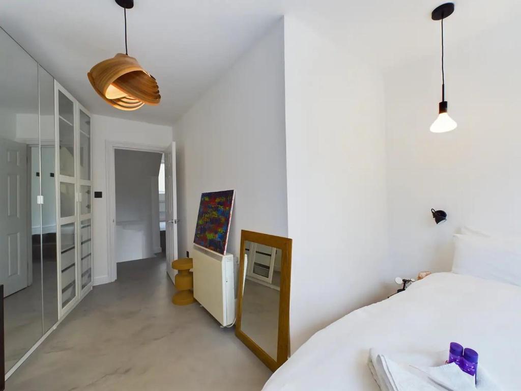 a bedroom with a bed and a painting on the wall at Pass the Keys Stylish and Modern 2Bed 2Bath Hackney Apartment in London