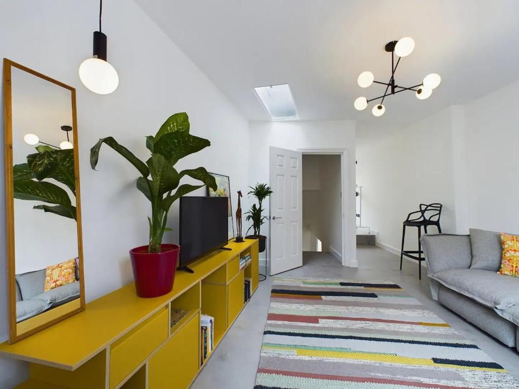 a living room with a yellow dresser and a couch at Pass the Keys Stylish and Modern 2Bed 2Bath Hackney Apartment in London