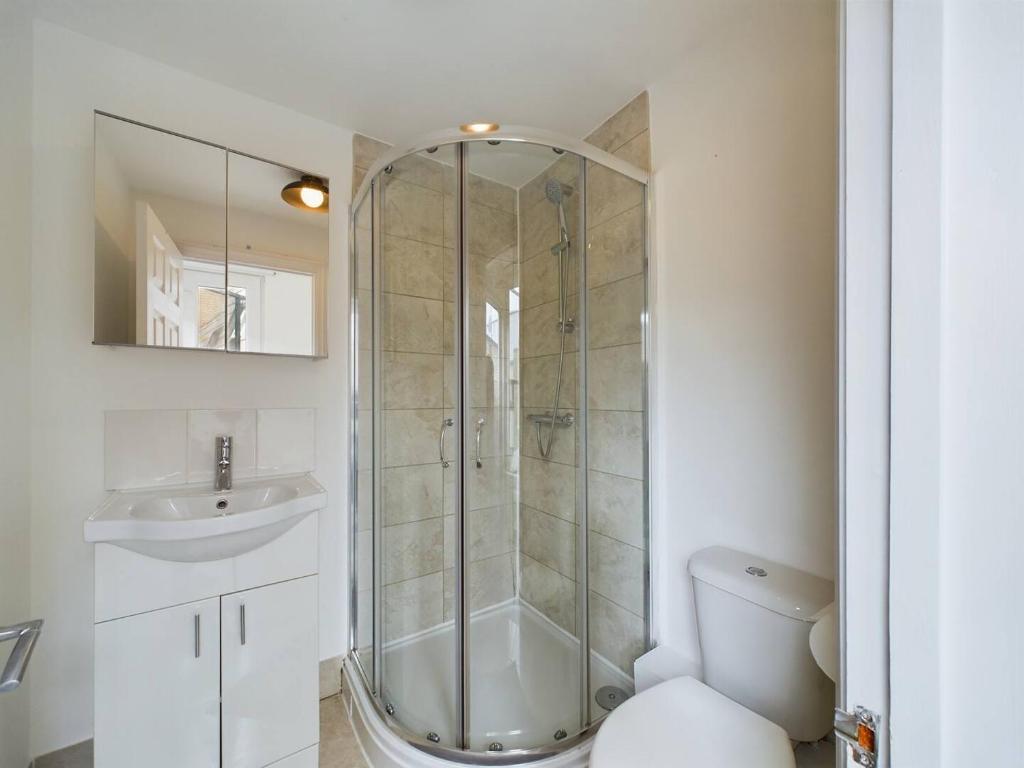 a bathroom with a shower and a toilet and a sink at Pass the Keys Stylish and Modern 2Bed 2Bath Hackney Apartment in London