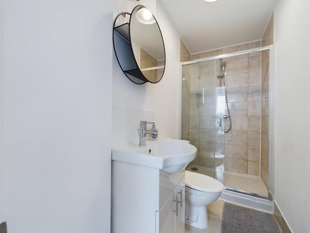 a bathroom with a sink and a toilet and a mirror at Pass the Keys Stylish and Modern 2Bed 2Bath Hackney Apartment in London
