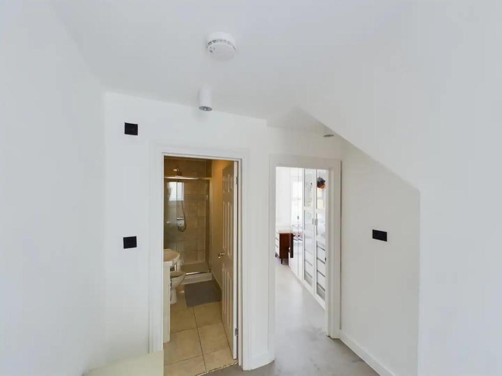 a hallway with white walls and a bathroom at Pass the Keys Stylish and Modern 2Bed 2Bath Hackney Apartment in London