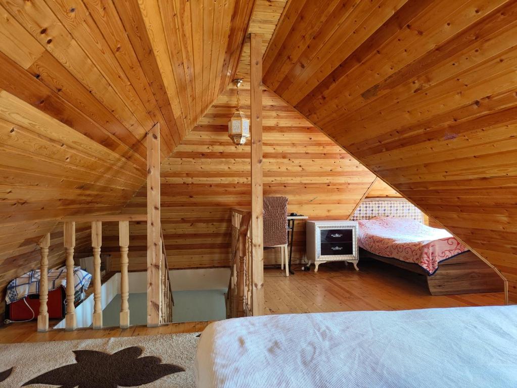 sypialnia z drewnianym sufitem i łóżkiem w pokoju w obiekcie Family House at Baku Olympic Stadium w mieście Baku