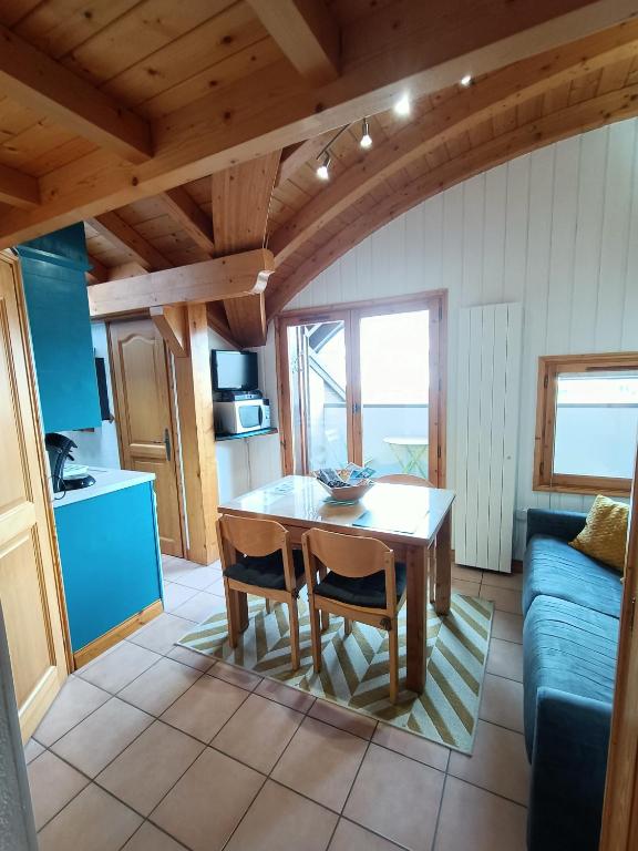 une cuisine et une salle à manger avec une table et des chaises dans l'établissement Cocon familial proche télécabine, à Saint-Gervais-les-Bains