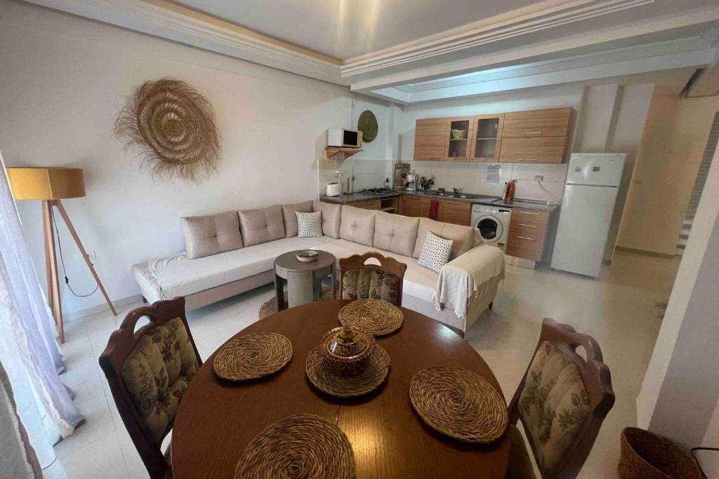 a living room with a table and a couch at Chott Meriem avec terrasse in Chott Meriem