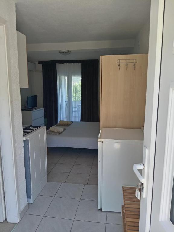 a kitchen with a bed in the middle of a room at Apartments Šešo B in Pag
