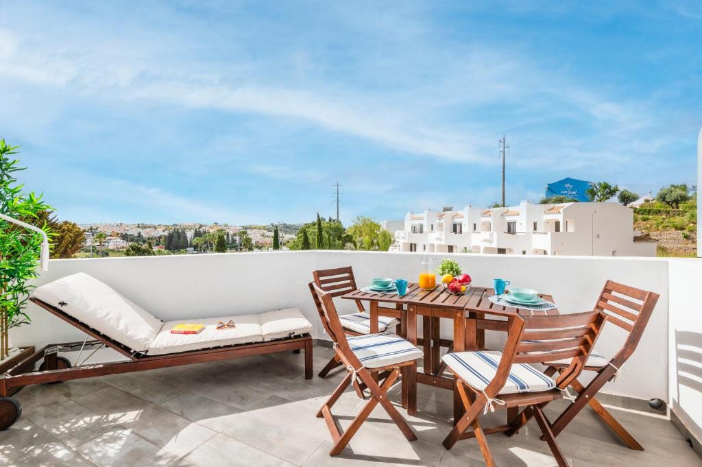 a patio with a table and chairs on a balcony at Clube Albufeira: 2BR Prime Holidays Retreat in Albufeira
