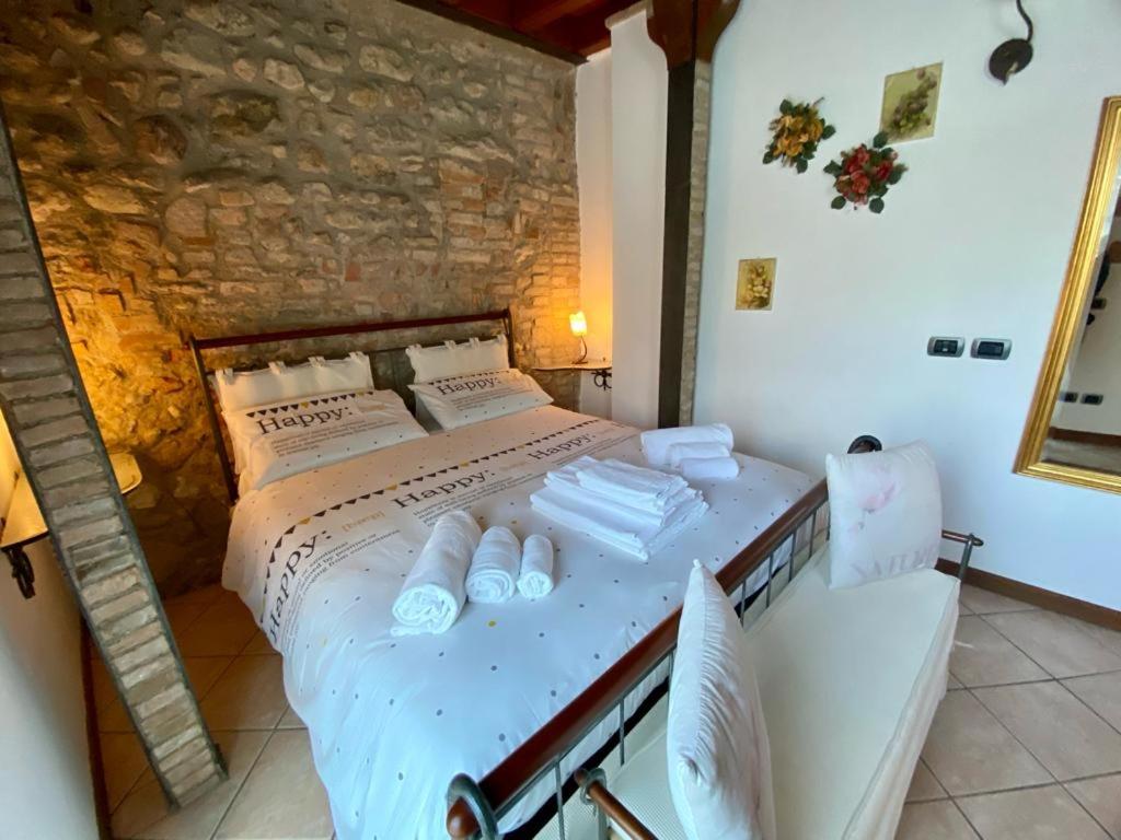 1 dormitorio con 1 cama con toallas en Garda Paradise Country House, en Lonato