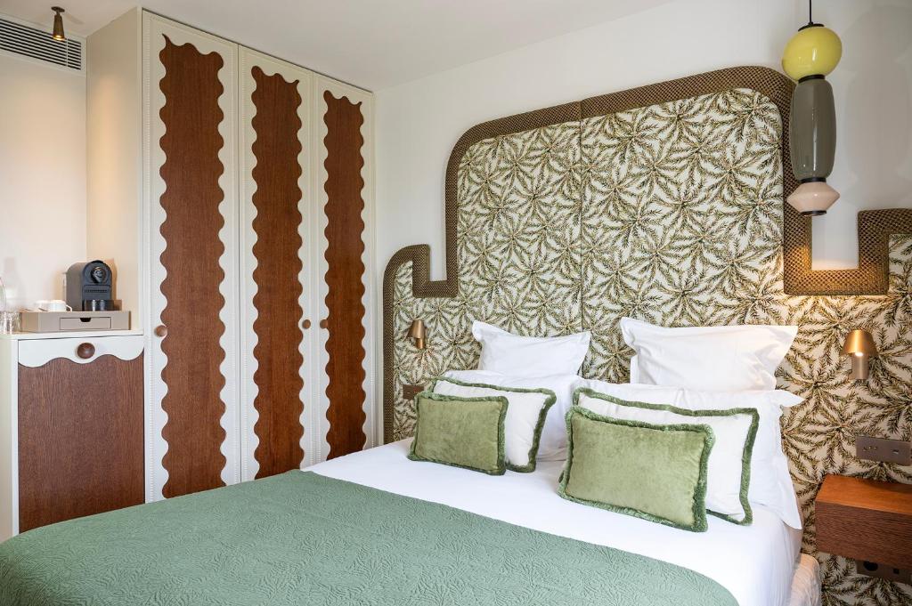 a bedroom with a large bed with a large headboard at Lou Cagnard in Saint-Tropez