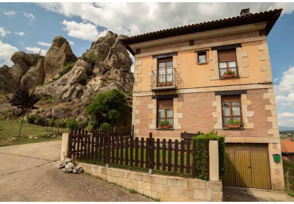 una casa con una valla delante de una montaña en Chanin I, en Pinilla de los Barruecos