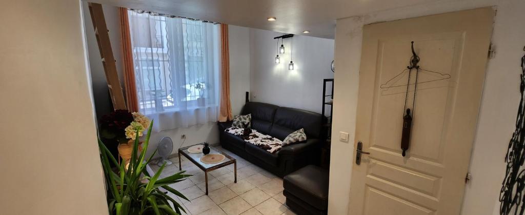 - un salon avec un canapé noir et une fenêtre dans l'établissement Appartement Cosy Centre Nice, à Nice
