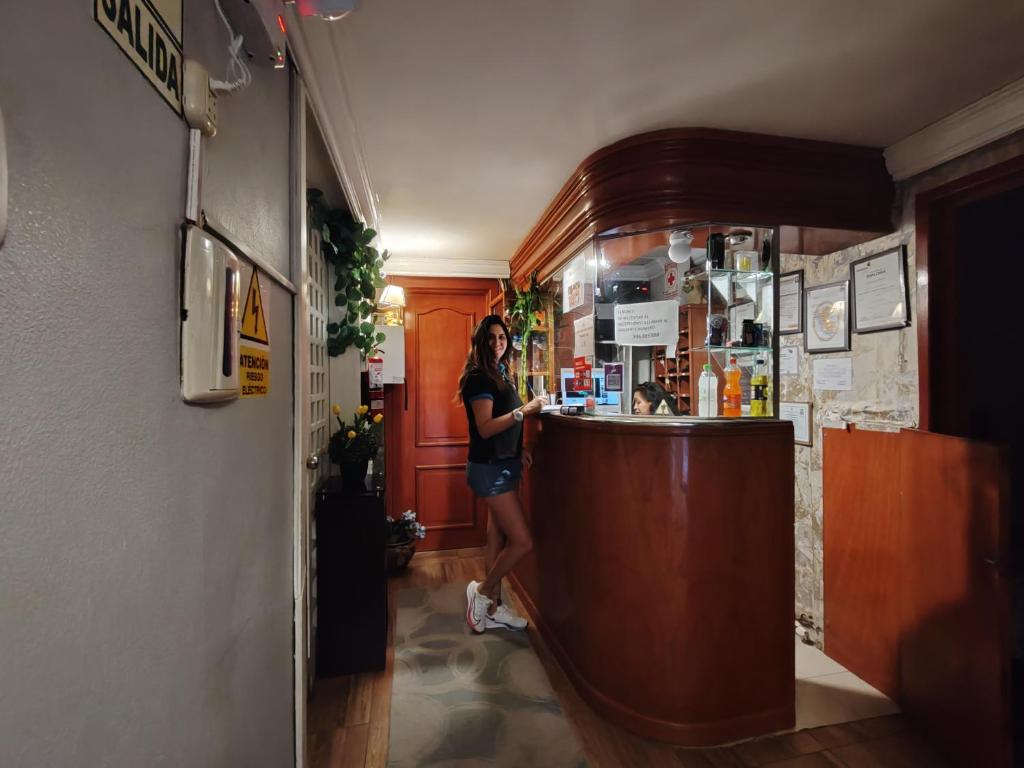a woman standing at a counter in a bar at Hostal COLUMBIA in Moquegua