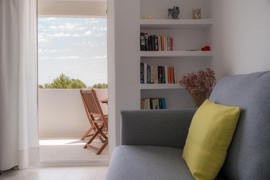 a couch with a yellow pillow in a living room at Mirada I in Es Pujols