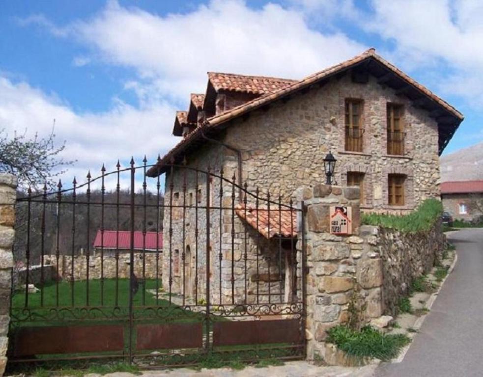 une maison en pierre avec une clôture devant elle dans l'établissement El Apartamento, à Robledo de la Guzpeña