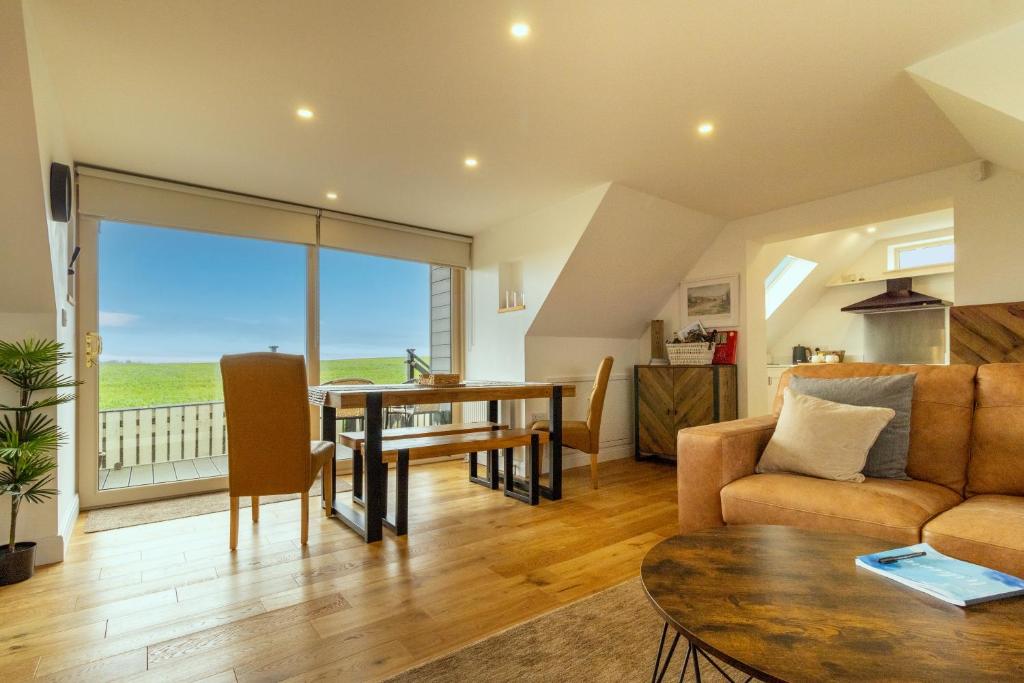 a living room with a table and a couch at Picturesque cottage with views 