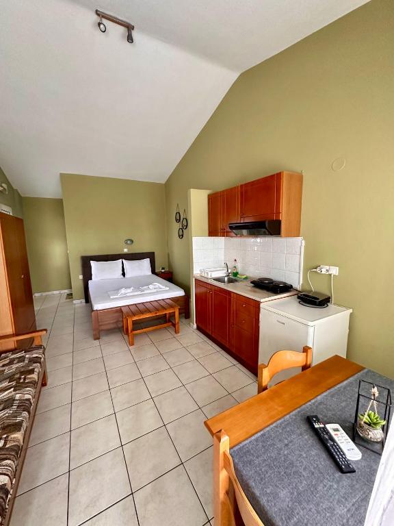 a room with a kitchen with a table and a couch at Artemis Hotel Apartments in Keramoti