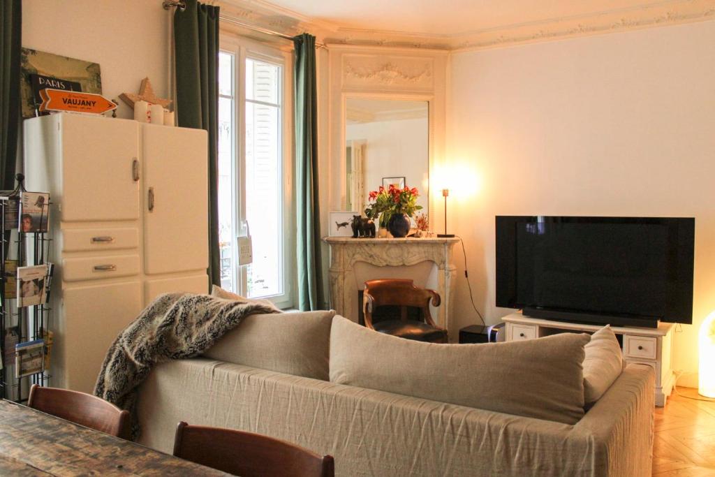 a living room with a couch and a television at Cozy and quiet apartment in the 15th in Paris