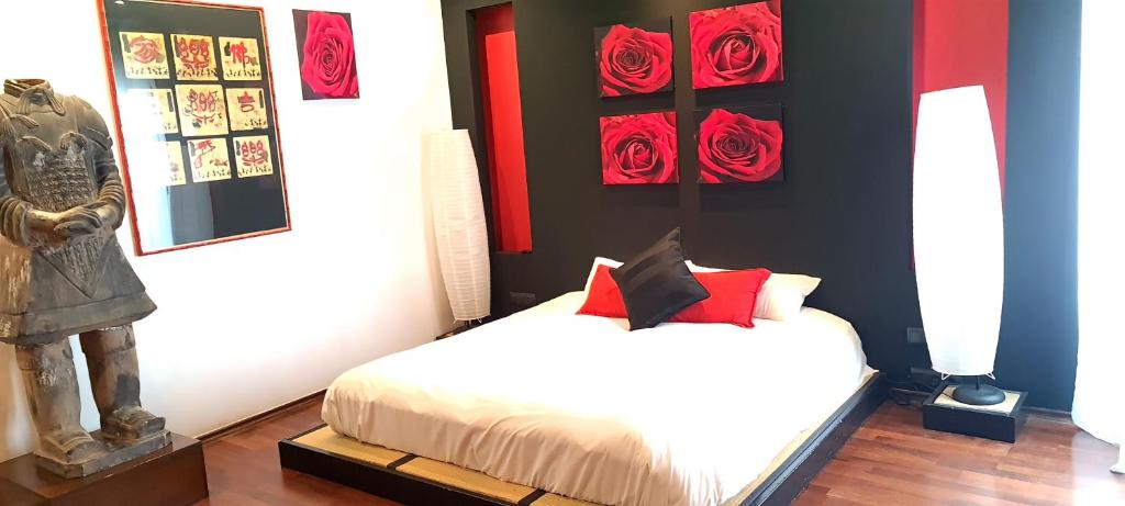 - une chambre avec un lit orné de roses rouges sur le mur dans l'établissement Apartamentos con jacuzzi, à Madrid
