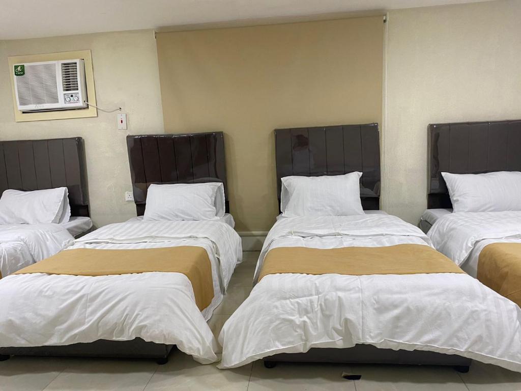 نزل حراء في جدة: سريرين في غرفة ذات أغطية بيضاء وبنية