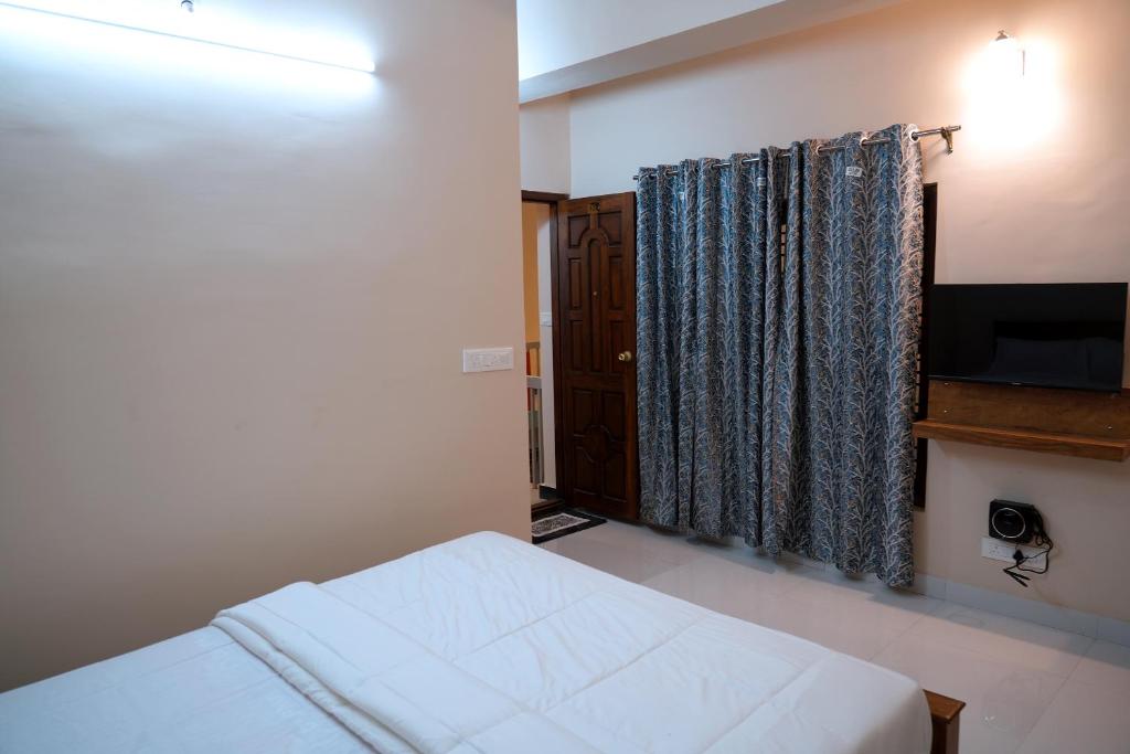 Postel nebo postele na pokoji v ubytování HILL PALACE RESIDENCY COORG