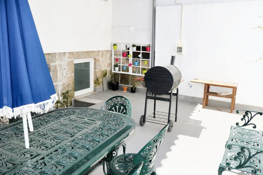 ラメーゴにある2 bedrooms house with furnished terrace and wifi at Lamegoのテーブルと椅子、グリルが備わる客室です。
