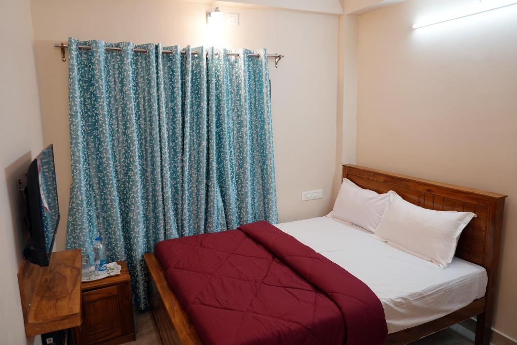 Postel nebo postele na pokoji v ubytování HILL PALACE RESIDENCY COORG